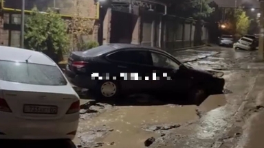 Алматыда қатты жаңбырдан жол опырылып, көліктер бүлінген